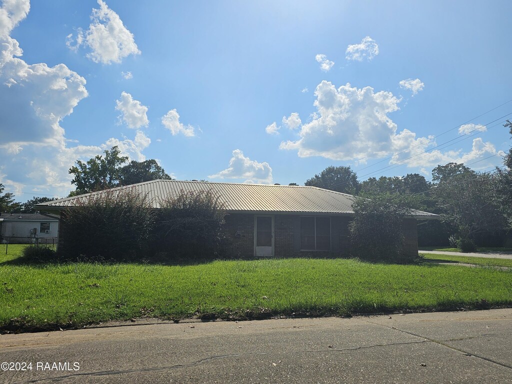 view of side of home featuring metal roof and a lawn