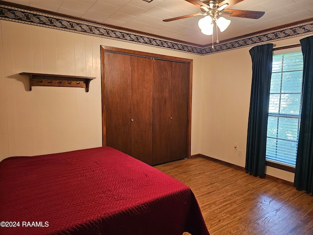 unfurnished bedroom with hardwood / wood-style flooring, ceiling fan, and a closet