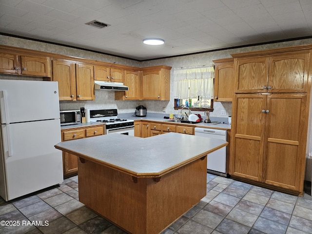 kitchen featuring sink, a kitchen island, white appliances, and ornamental molding