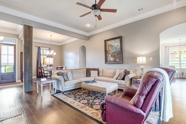 living room with ceiling fan with notable chandelier, crown molding, and dark hardwood / wood-style floors