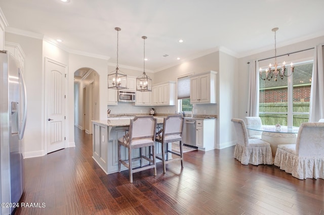 kitchen featuring pendant lighting, a center island, appliances with stainless steel finishes, and dark hardwood / wood-style flooring