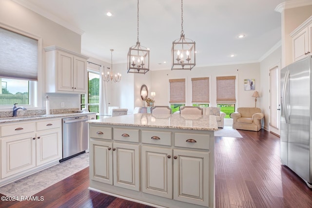 kitchen with appliances with stainless steel finishes, a center island, dark wood-type flooring, and decorative light fixtures