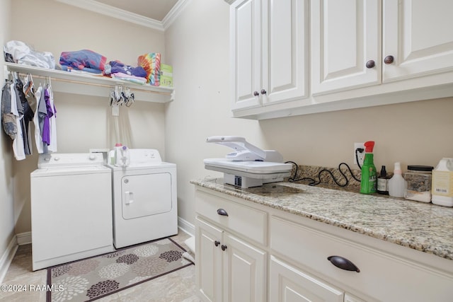 laundry area featuring ornamental molding, independent washer and dryer, and cabinets