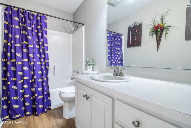 full bathroom featuring toilet, wood-type flooring, shower / bathtub combination with curtain, and vanity