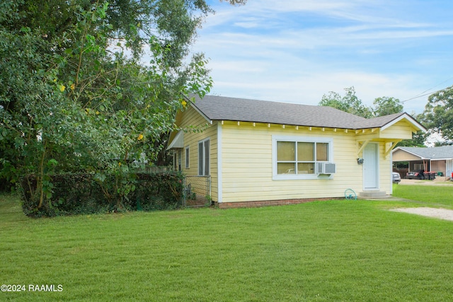 view of front of house featuring cooling unit and a front yard