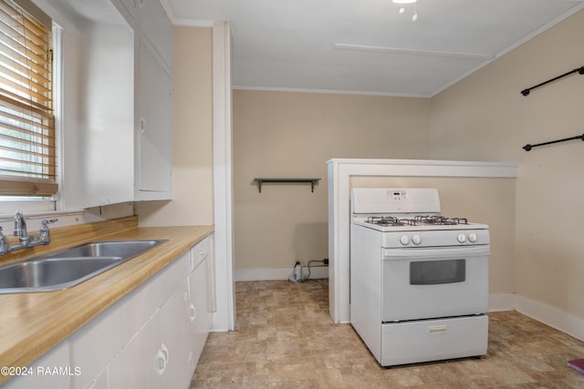 kitchen featuring ornamental molding, white range with gas stovetop, sink, and white cabinetry