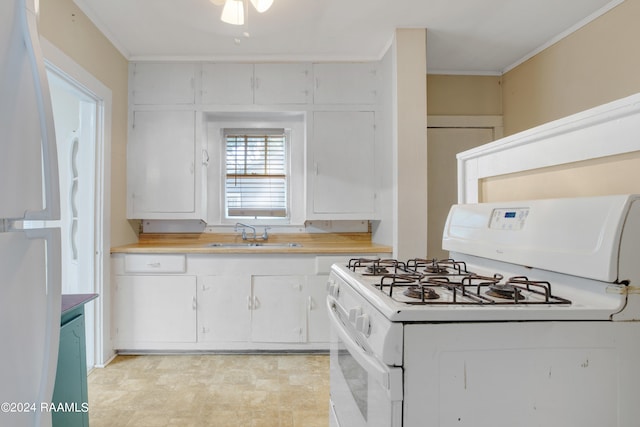 kitchen featuring white cabinets, crown molding, sink, and white gas range