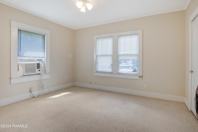 spare room with light carpet, plenty of natural light, and ornamental molding