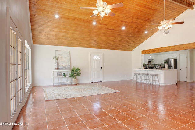 entrance foyer with ceiling fan, wood ceiling, light tile patterned floors, and high vaulted ceiling