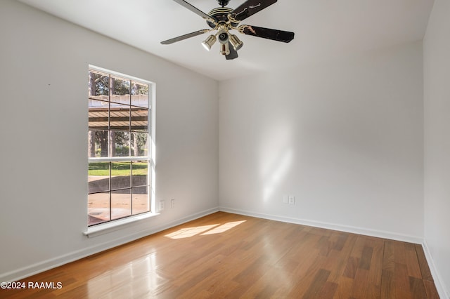 unfurnished room featuring ceiling fan, hardwood / wood-style flooring, and a healthy amount of sunlight