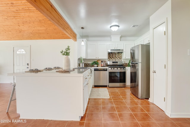 kitchen featuring beam ceiling, kitchen peninsula, white cabinetry, hanging light fixtures, and appliances with stainless steel finishes