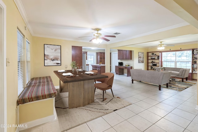 dining space featuring ceiling fan, light tile patterned floors, and crown molding