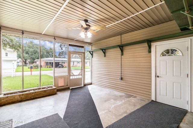 unfurnished sunroom with ceiling fan