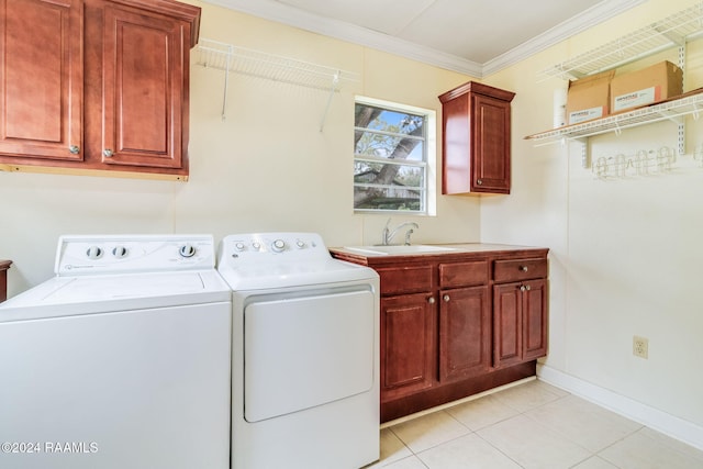 clothes washing area featuring cabinets, sink, light tile patterned floors, crown molding, and independent washer and dryer