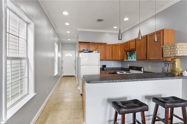 kitchen featuring ornamental molding, freestanding refrigerator, range with electric cooktop, and a peninsula