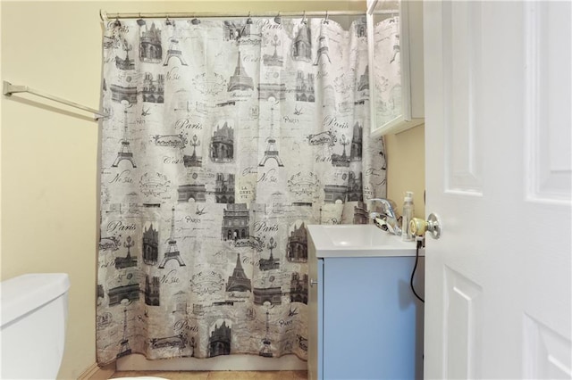 bathroom with curtained shower, vanity, and toilet