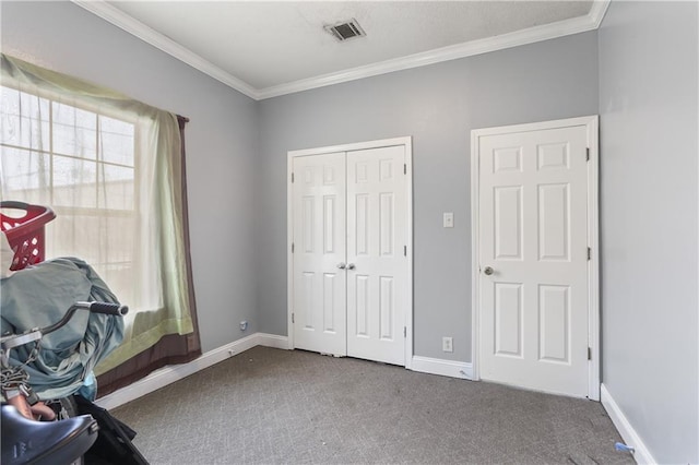 unfurnished office featuring ornamental molding, carpet flooring, visible vents, and a healthy amount of sunlight