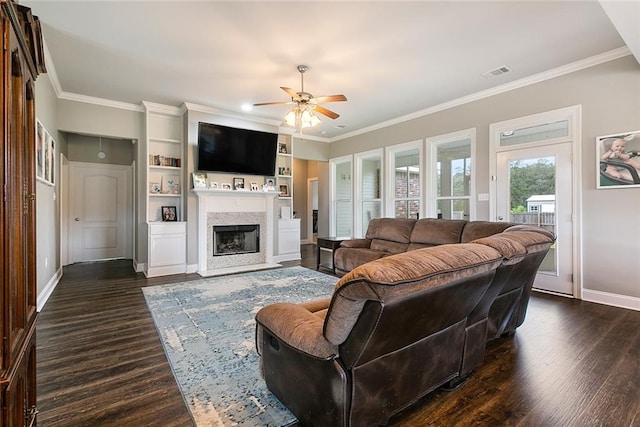 living area featuring baseboards, visible vents, dark wood finished floors, a premium fireplace, and crown molding