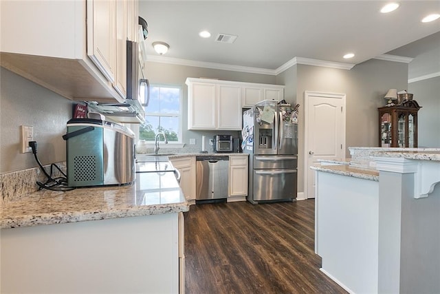 kitchen with appliances with stainless steel finishes, dark wood-type flooring, crown molding, and white cabinetry