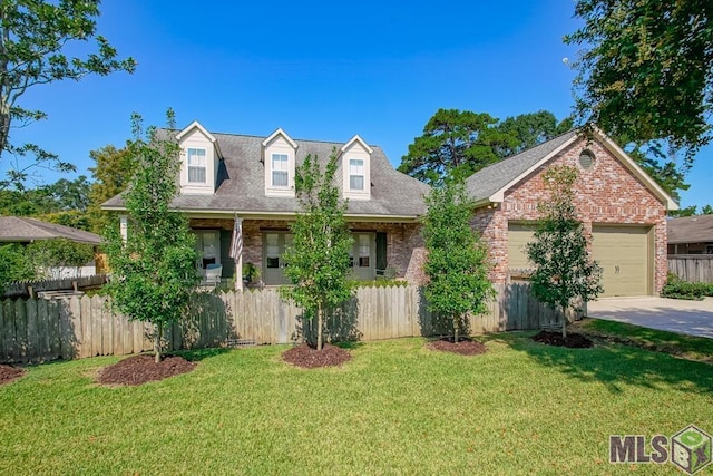 new england style home featuring a fenced front yard, a front yard, concrete driveway, and brick siding