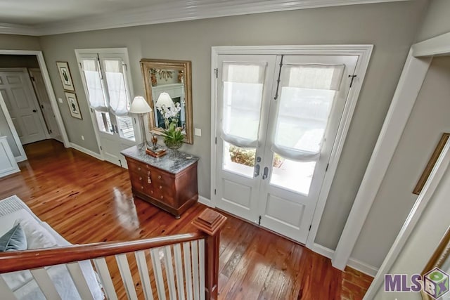 foyer entrance with ornamental molding, french doors, wood finished floors, and baseboards