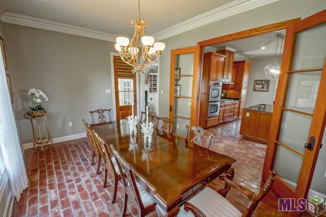 dining space with brick floor, baseboards, a chandelier, and crown molding