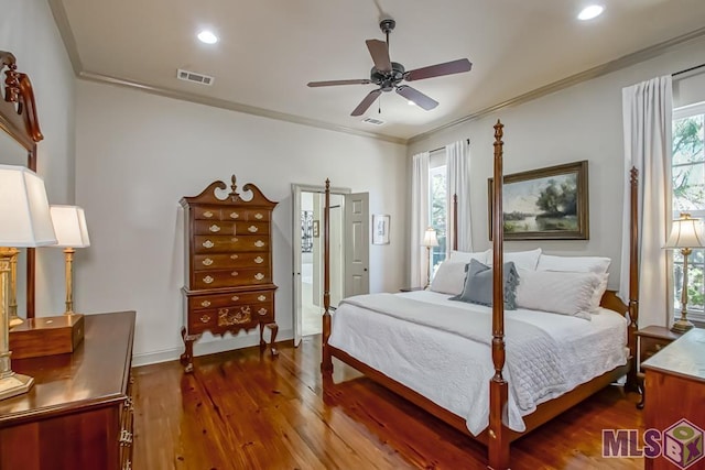 bedroom with dark wood-style floors, visible vents, crown molding, and recessed lighting