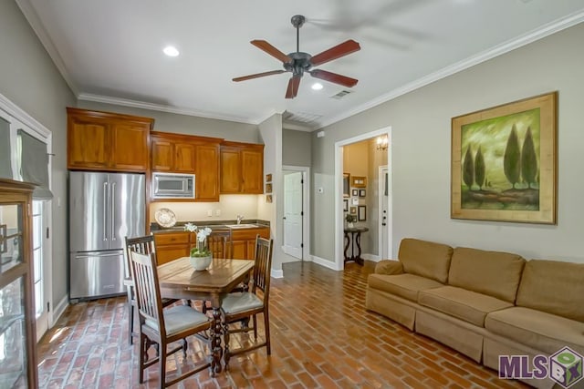 dining room featuring baseboards, brick floor, visible vents, and crown molding