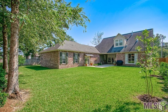 back of property with a patio area, fence, and brick siding