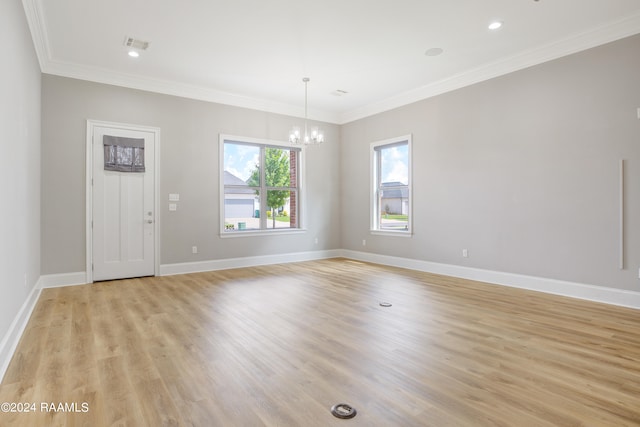 interior space featuring ornamental molding, a notable chandelier, and light hardwood / wood-style floors