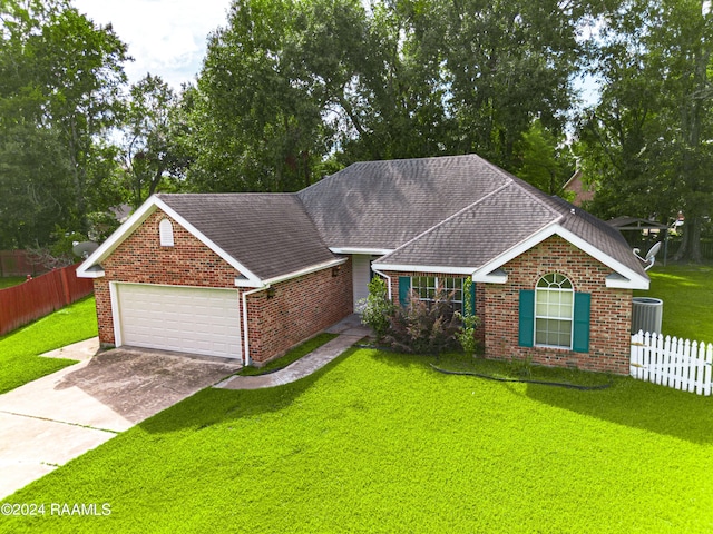 ranch-style house featuring a garage, central AC unit, and a front yard