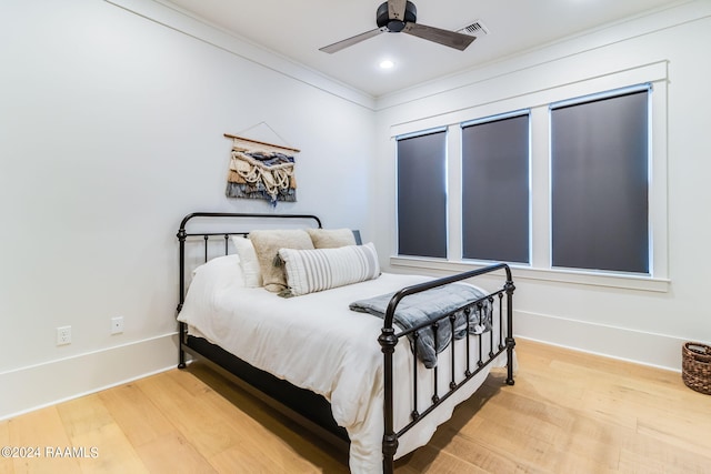 bedroom featuring ceiling fan, hardwood / wood-style floors, and crown molding