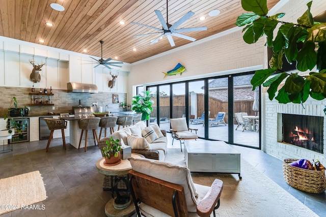 living room with beverage cooler, ceiling fan, wooden ceiling, and a fireplace