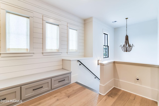 interior space with hardwood / wood-style flooring, wooden walls, and plenty of natural light