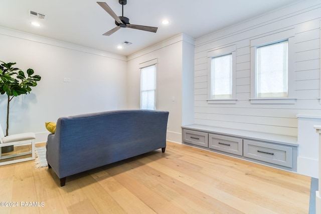 living room featuring ornamental molding, ceiling fan, light hardwood / wood-style floors, and a healthy amount of sunlight