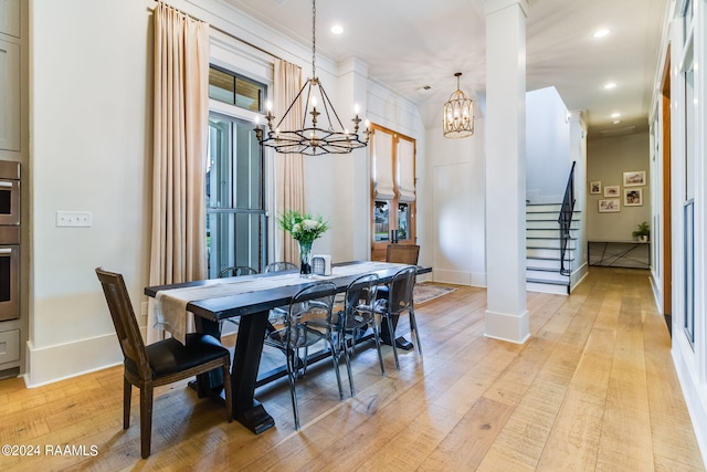 dining room with ornamental molding, light hardwood / wood-style flooring, and a chandelier