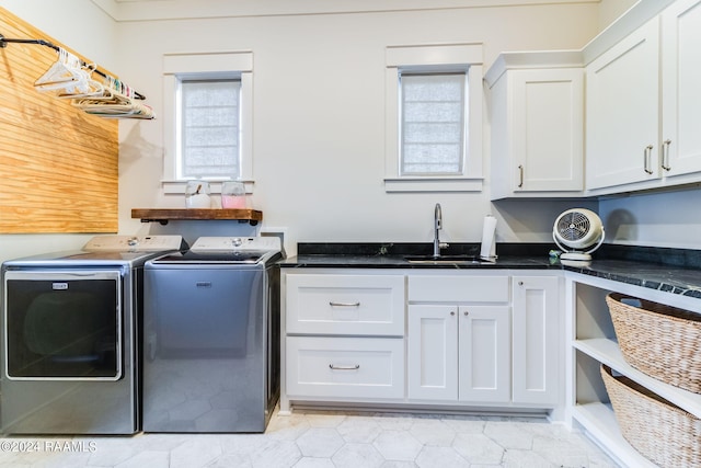 washroom featuring separate washer and dryer, cabinets, and sink