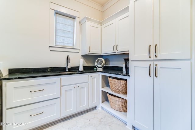 laundry room featuring light tile patterned floors, ornamental molding, and sink