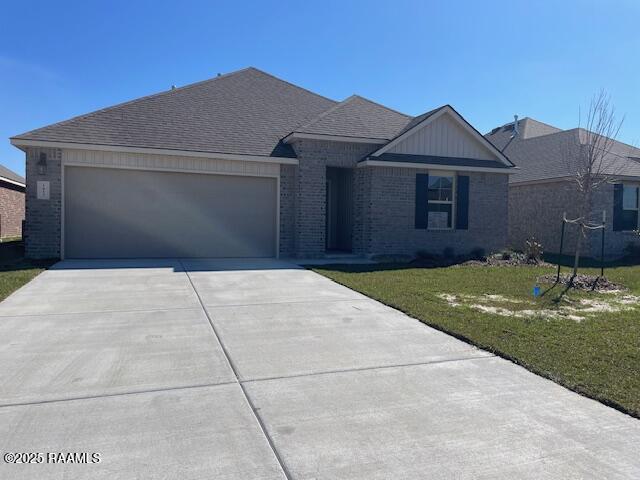 ranch-style home with a garage, a front yard, concrete driveway, and brick siding