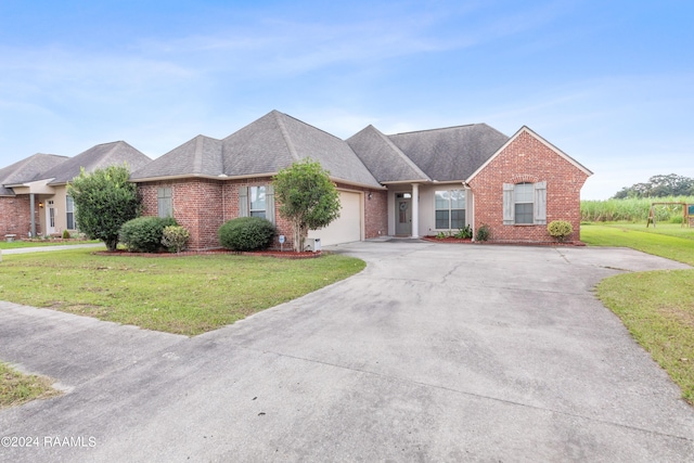 ranch-style house with a garage and a front lawn