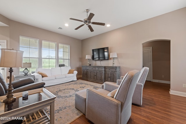 living room featuring ceiling fan and dark wood-type flooring