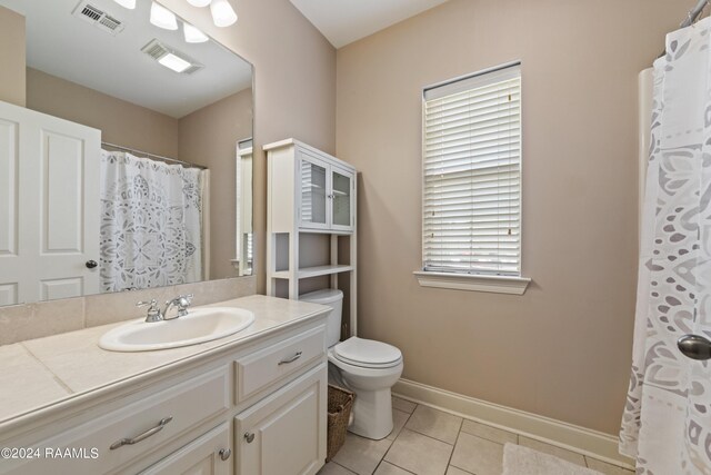 bathroom featuring vanity, tile patterned floors, toilet, and a healthy amount of sunlight