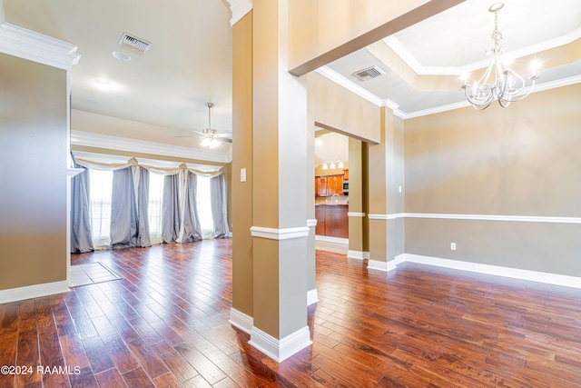 unfurnished room featuring dark wood-type flooring, crown molding, decorative columns, and ceiling fan with notable chandelier