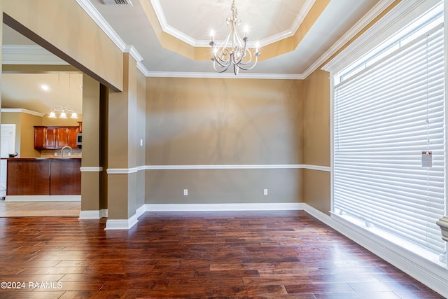 unfurnished room featuring dark wood-type flooring, a tray ceiling, ornamental molding, sink, and a chandelier