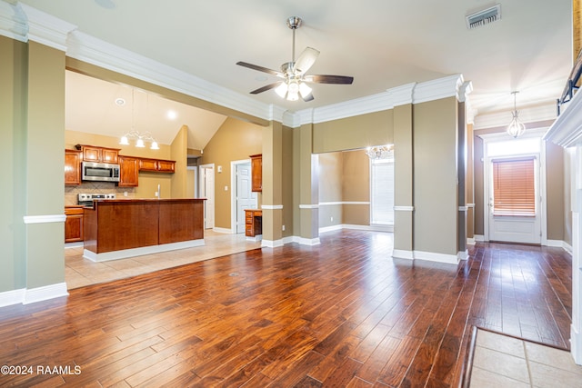 unfurnished living room with vaulted ceiling, ornamental molding, wood-type flooring, and ceiling fan with notable chandelier