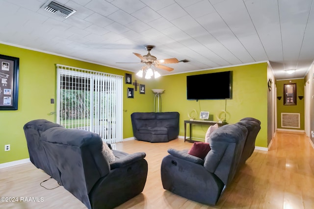 living room featuring light hardwood / wood-style floors, ornamental molding, and ceiling fan