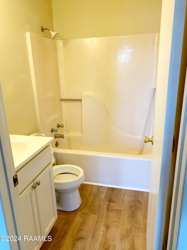 full bathroom with  shower combination, toilet, vanity, and hardwood / wood-style flooring