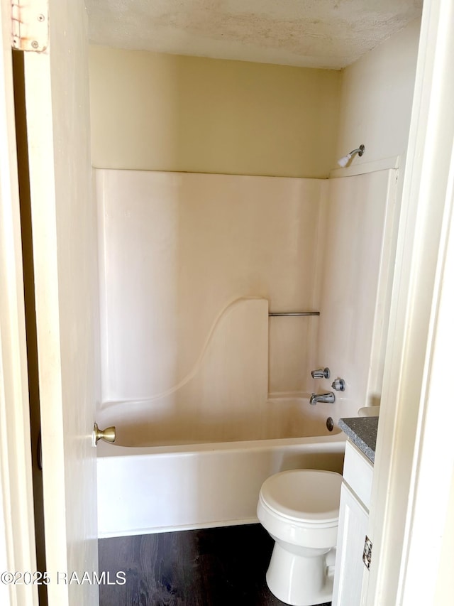 full bathroom with toilet, a textured ceiling, shower / bathtub combination, and vanity