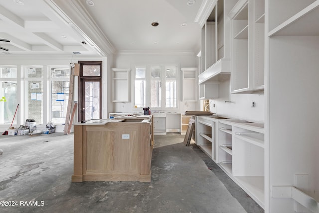 kitchen featuring a center island, plenty of natural light, white cabinetry, and ornamental molding