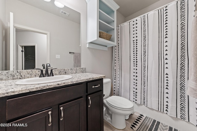 bathroom with vanity, toilet, and tile patterned floors